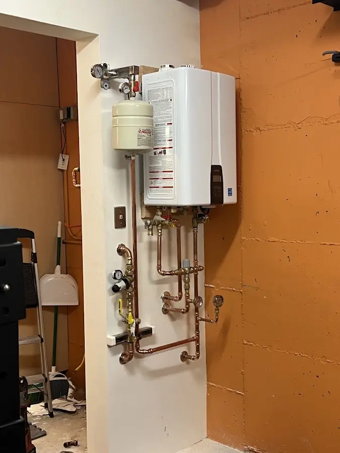 Plumbing technician inspecting water heater connections in Huron